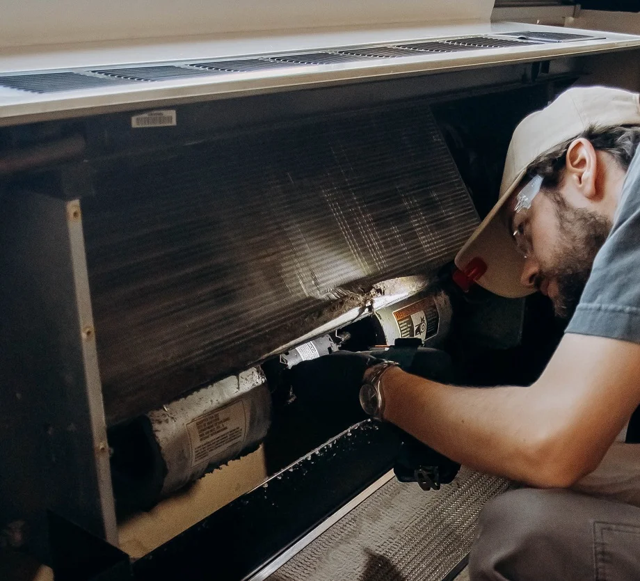 Technician working on internal components of a packaged terminal air conditioner