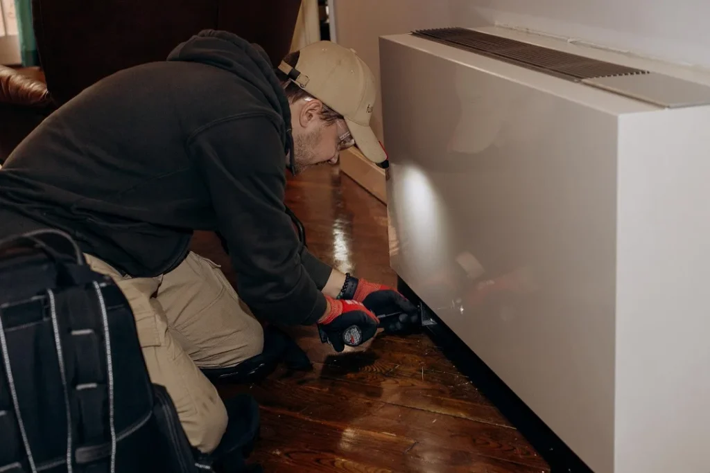 Technician working on a wall-mounted packaged terminal HVAC unit