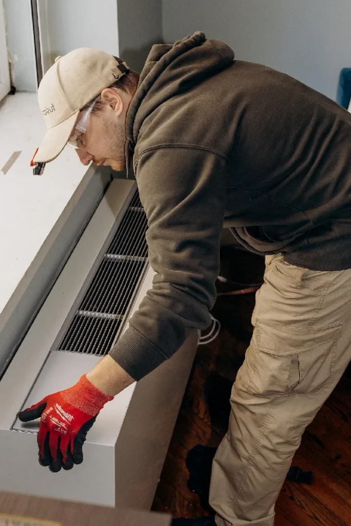 HVAC technician fitting a replacement PTAC into an existing wall sleeve