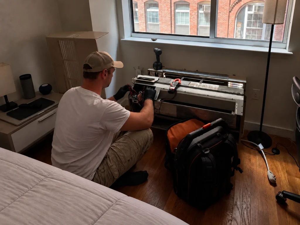 Technician working on an open packaged terminal AC unit